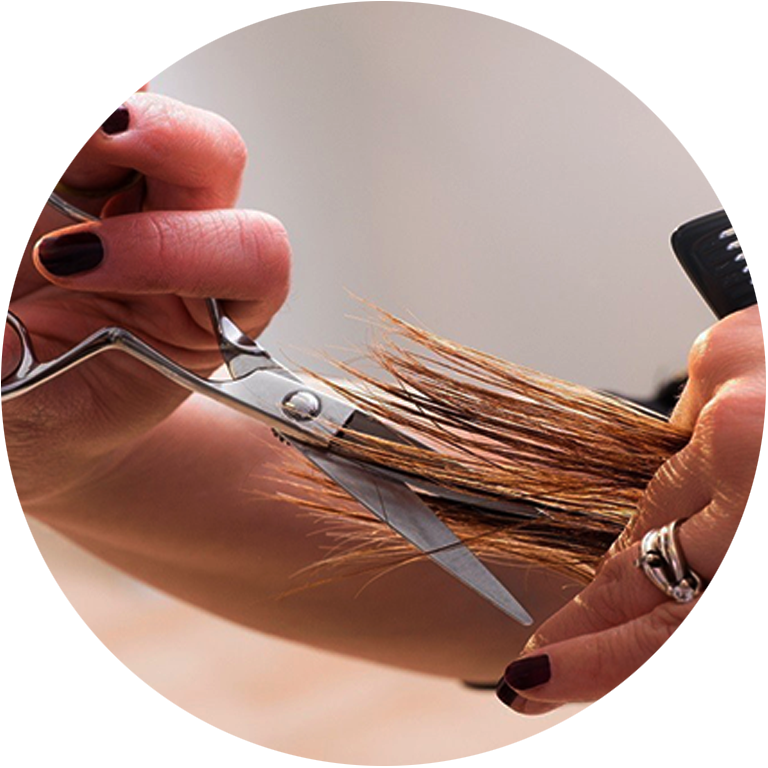Apprentie coiffeuse à l'Ecole des Métiers Dijon Métropole affine les pointes au salon.